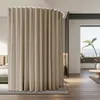 A room divided by a beige curtain, with a bed on one side and a lounge area with plants and a window on the other. Produktbild-Vorschau