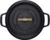 A top-down view of a black Staub cast iron pot with a gold handle. Náhled obrázku produktu