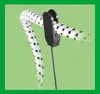 A close-up of a black clip holding a white and black patterned elastic cord. Podgląd zdjęcia produktu