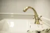 A close-up shot of a vintage-style brass faucet over a white sink. Anteprima dell’immagine prodotto