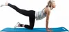 A woman is performing a yoga pose on a blue yoga mat. Produktbild-Vorschau