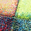 A close-up view of a colorful, textured rug with a geometric pattern. Náhled obrázku produktu