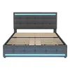 A gray upholstered bed frame with a tufted headboard and footboard, featuring blue LED lighting along the top of the headboard and the bottom of the frame. The wooden slats for the mattress are visible. Produktbild-Vorschau