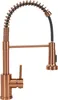 A copper-colored kitchen faucet with a pull-down sprayer and a coiled hose. Anteprima dell’immagine prodotto