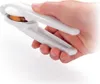 A hand holding a white nutcracker with a nut inside. Produktbild-Vorschau