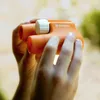 Hands holding orange binoculars outdoors. Náhľad obrázku produktu