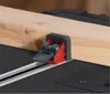 A close-up of a woodworking clamp holding a piece of wood on a workbench. Náhľad obrázku produktu