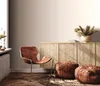 A stylish living room corner with a leather chair, poufs, and a decorative cabinet. Produktbild-Vorschau