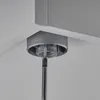A close-up view of a gray furniture foot being attached to a ceiling or shelf with a screwdriver. Produktbild-Vorschau