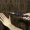 A close-up shot of a person using a wire twisting tool to secure a privacy screen made of natural materials. Produktbild-Vorschau
