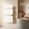 A woman is relaxing in a bathtub next to a white electric towel warmer mounted on a beige wall. Produktbild-Vorschau