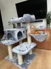 A cat is relaxing on a multi-level cat tree in a living room setting. Náhled obrázku produktu
