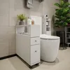 A slim white cabinet with drawers and shelves next to a toilet in a bathroom. Náhľad obrázku produktu