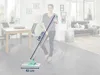 A woman is using a floor wiper in a living room. Produktbild-Vorschau