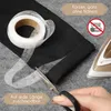 A person is cutting a roll of hemming tape with scissors next to a black fabric and an iron, indicating a sewing or crafting process. Náhled obrázku produktu