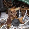 A close-up view of the cutting mechanism of a leaf blower, clogged with leaves and debris. Produktbild-Vorschau