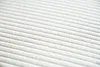 A close-up, diagonal view of a cream-colored corduroy fabric with raised ridges. Produktbild-Vorschau
