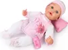 A baby doll lying on its back, dressed in pink and white clothing, with a pacifier and bottle. Podgląd zdjęcia produktu