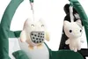 Close-up of two plush toys hanging from a green baby swing or high chair. Produktbild-Vorschau