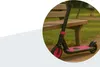 A pink and black scooter is leaning against a wooden park bench. Anteprima dell’immagine prodotto