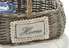 A close-up of a woven basket with a decorative patch that says 'Home'. Produktbild-Vorschau
