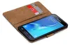A brown book-style case for a Samsung Galaxy J7 2016 phone, with two credit cards inserted into a slot. Podgląd zdjęcia produktu