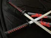Two katana swords are crossed on a black fabric background. Voir les images du produit