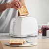 A person is placing toast into a white Russell Hobbs toaster, with a jar of jam and more toast visible on the counter. Podgląd zdjęcia produktu