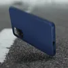 A dark blue phone case is shown at an angle on a textured surface. Podgląd zdjęcia produktu