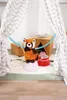A stuffed red panda toy is placed inside a teepee-like tent, surrounded by decorative items. Anteprima dell’immagine prodotto