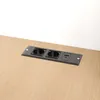 A close-up shot of a power outlet strip with two sockets and a USB port, embedded in a wooden surface. Podgląd zdjęcia produktu