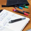 Pens and a notebook on a wooden desk. Anteprima dell’immagine prodotto