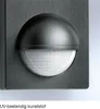A close-up of a black motion sensor mounted on a textured gray surface. Anteprima dell’immagine prodotto