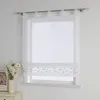 A white sheer Roman blind with embroidered floral detail is shown hanging in a window. Produktbild-Vorschau