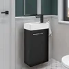 A modern bathroom vanity with a black cabinet and white sink, set against a tiled wall. Produktbild-Vorschau