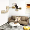 A cat is playing on a wall-mounted cat tree in a living room with a sofa and coffee table. Náhled obrázku produktu