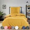 A bed with yellow bedding is shown in a room with a plant and a bookshelf. Produktbild-Vorschau