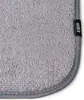 A close-up view of the corner of a gray fabric mat with a black label. Náhled obrázku produktu