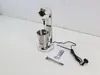 A silver milkshake maker and frother with a stainless steel cup and a manual are placed on a white surface. Produktbild-Vorschau