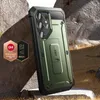 A rugged, dark green phone case with a kickstand is displayed on a textured, rocky surface with dry grass. Náhľad obrázku produktu