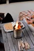 People making s'mores around a portable fire pit. Produktbild-Vorschau