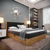 A bedroom scene featuring a boxspring bed, nightstands, lamps, a mirror, and a bookshelf. Podgląd zdjęcia produktu