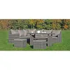 A wicker lounge set with cushions and a table is placed on a grassy lawn with trees in the background. Produktbild-Vorschau