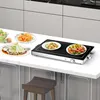 A sleek electric griddle with two plates of food, sitting on a kitchen counter. Produktbild-Vorschau