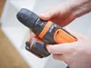 A person's hands are holding and adjusting a cordless drill. Podgląd zdjęcia produktu