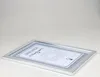 A silver-colored document or picture frame with a certificate inside, lying flat on a white surface. Produktbild-Vorschau