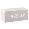 A digital alarm clock with a wood-grain finish and a wireless charging pad on top. Produktbild-Vorschau