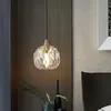 A crystal pendant light hangs above a bedside table with a vase and plant. Podgląd zdjęcia produktu