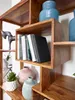 A close-up view of a wooden bookshelf filled with books and decorative items. Podgląd zdjęcia produktu