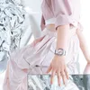 A person wearing a pink outfit and a pink G-Shock watch, posing with metallic, reflective surfaces. Produktbild-Vorschau
